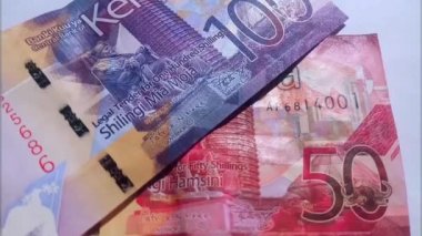 Yakın çekim, Kenya 'nın elli ve yüz şilinlik banknotlarının slayt çekimi. Video klibi. Nakit, para, para.