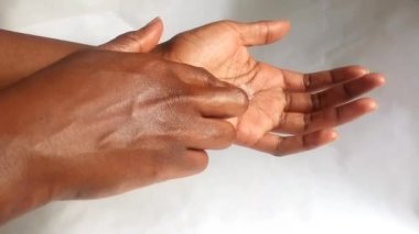 Parmak görüntülerindeki vücut kremi jölesi sürerken ve sürerken bir bayanın ellerini kapat. Güzellik, cilt bakımı kozmetik ürün konsepti. Sade. Afrikalı, etnik köken, çeşitlilik.