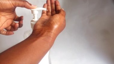 El sıkan el dezenfektanı sıvı jel görüntülerinde. Renksiz alkol dezenfekte edici jel video klibini gösteriyor. Afrikalı Amerikalı. Çeşitlilik, konsept. Etnik köken. Coronavirus hijyen konsepti. Kopyalama alanı.