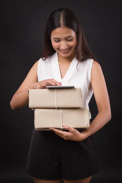 woman shopping online with tablet, holding parcel delivery box