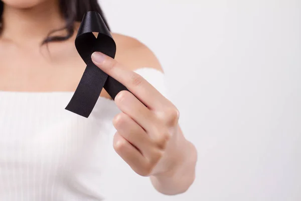 woman hand holding black ribbon bow, sad unhappy mourning woman, studio white isolated of asian young adult model