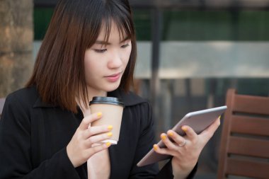 bilgisayar tablet kullanan iş kadın; Onun kullanışlı taşınabilir bilgisayar tablet vasıl seyir işkadını çalışma, holding, resmi kıyafetli portresi; Asyalı Çinli Genç Yetişkin kadın modeli