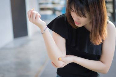 kadın dirsek eklem kemik yaralı yaralı; acı dirsek eklem ağrısı yaralanma, romatoid veya gut artrit sağlık kavramı hasta yaralı kadın portresi; Genç Yetişkin Asyalı kadın modeli