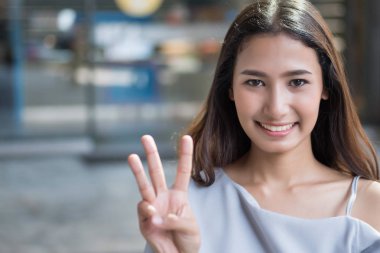 mutlu kız sayısı 3 parmak işaret; neşeli mutlu gülümseyen Asyalı kadın el üç parmak ile işaret eden oktan yukarı portresi; sayı kavramını üç, 3 puan, Üçüncülük; Asyalı kadın genç yetişkin modeli