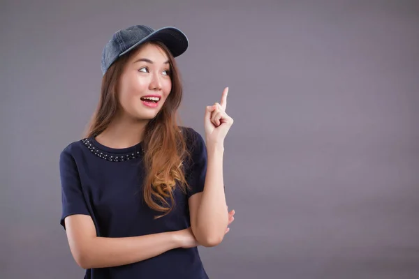 confident girl, happy woman pointing up gesture; portrait of confident happy successful asian woman pointing finger at you; showing, advertising, focusing point concept; asian young adult woman mode