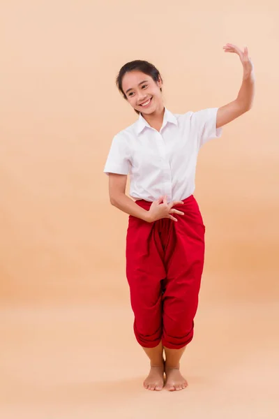 Thai performance art, woman dancer student dancing in traditional red loincloth; studio portrait of woman dancer in asian Thai traditional elegant dance move; young adult asian woman dancer model