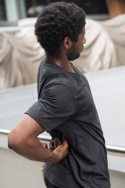 Sırt ağrısı çeken bir adam, eklem ağrısı, osteoporoz, kemik eklem iltihabı, gut, semptomlar, vücut hastalığı, sağlık hizmetleri veya ağrı konsepti olan hasta Afrikalı bir adam, yetişkin bir Afrikalı ya da zenci manken.