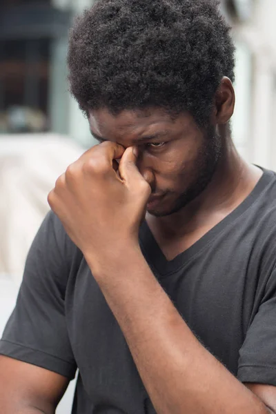 portrait of stressed sick african man with headache; ill african man or black man suffers from headache, vertigo, dizziness, migraine, stress, depression, hangover concept; adult african man model