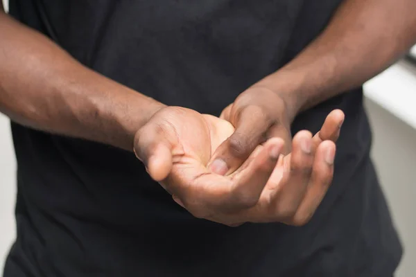 african man suffering from wrist or hand pain; sick black man with cps wrist pain, trigger finger, bone arthritis, gout symptoms; sickness, health care or pain concept; adult african man model