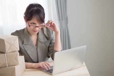 Asyalı kadın onun dizüstü bilgisayar ve kurye parsel kutusunu çalışma vurguladı; üzücü mutsuz kadın işletme sahibi iş başarısızlık, kaybı kavramı ile portresi; Yetişkin Asyalı Çinli kadın modeli