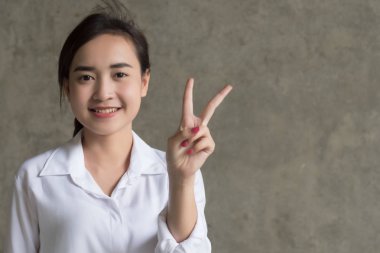 Asya iş kadını iki parmak işaret; portre pozitif bir parmak, v zafer kavramı için yukarı işaret Asya işkadını kazanan gülümseyen mutlu; Asya Çin 20'li yaşlarda genç yetişkin kadın modeli