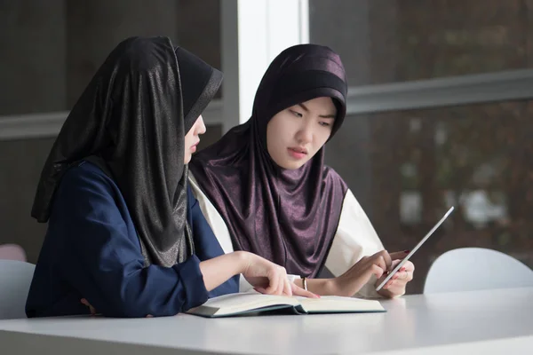 back to school with serious muslim woman college students; portrait of islamic woman students with hijab studying hard in college level education, back to school concept; asian young adult woman model