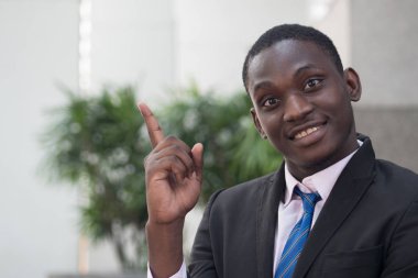 mutlu ve kendine güvenen Afrika işadamı yukarı dönük; kendine güvenen, başarılı Afrika veya siyah iş adamı, yönetici, iş yürütme portresi alana işaret; Genç Yetişkin Afrika man modeli