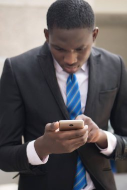 Afrika iş adamı Smartphone kullanarak; Bu akıllı telefon genel kavram-in hareket eden aygıt teknolojisi, Internet telekomünikasyon ile çalışan siyah işadamı portresi; Genç Yetişkin Afrika man modeli