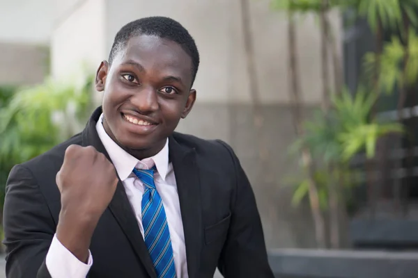 confident winning african businessman; portrait of successful confident african or black business man, manager, business executive winner being happy with success; young adult african man model