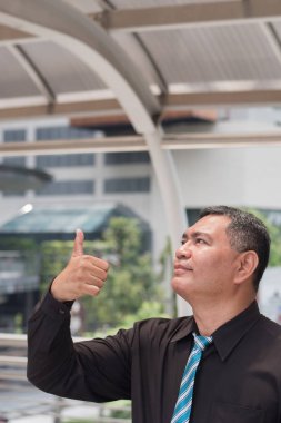 yukarı dönük, gösterilen, konsept sunmak eski iş adamı; parmak işaret veya el kadar boş yer işaret kendine güvenen, başarılı Asya iş adamı portresi; 50'li eski Güney Doğu Asya man modeli