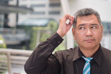 Yaşlı adam gri saç uğrar; gri, beyaz saç, saç dökülmesi problemi yaşlanma ile vurguladı, üzgün, şişman, mutsuz, eski Asya kıdemli adam portresi; saç bakım kavramı; Güney Doğu Asya eski üst düzey man modeli