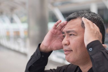 hasta eski üst düzey adam headahce uğrar; çok stresli, ciddi, hasta yaşlı Asya kıdemli adamla baş ağrısı, migren, baş dönmesi, baş dönmesi, stres, portresi; Güney Doğu Asya eski üst düzey man modeli