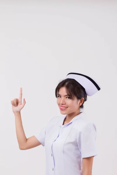 友好的亚洲女护士指指点点或显示的东西 工作室孤立的年轻亚洲成年妇女模型上的医疗护士的作用 — 图库照片