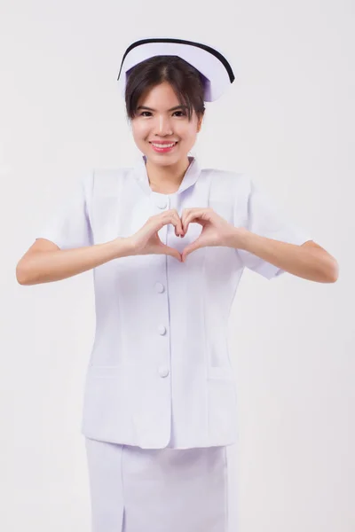 happy, smiling asian woman nurse with heart hand gesture; studio isolated portrait of asian female nurse doing heart gesture for heart attack, heart failure concept; asian 20s young adult woman model