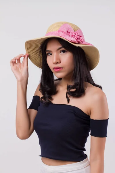 happy confident woman wearing summer travel hat. portrait of positive optimistic woman traveller, studio white isolated with holiday or vacation concept. young adult beautiful girl asian woman model