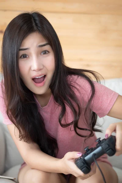 excited woman playing console video game. portrait of excited and fun asian woman plaing vdo game. hobby, liesure activity concept. asian young adult woman model