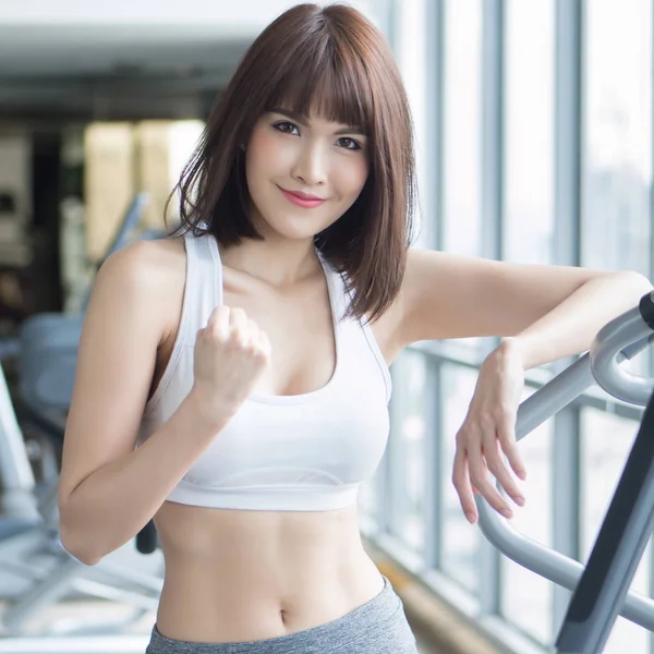 healthy strong fitness woman working out in gym. portrait of fitness woman in gym posing for strong body, gym workout, fitness people, healthy lifestyle concept. asian adult fitness woman model