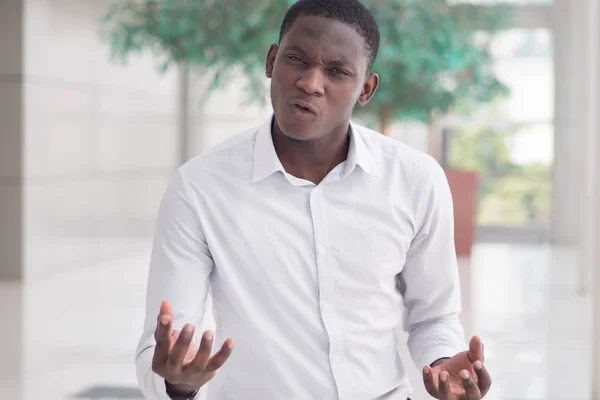 Angry African man shrugging with problem; portrait of angry, upset African black man feeling frustrated with problem, bad issue; African young adult man model