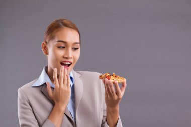 Pizza yemek mutlu gülümseyen Asyalı kadın; Lezzetli İtalyan pizza tutan Güney Doğu Asya kadın portresi; pizza kavramı yeme keyfini; Asya genç yetişkin, kahverengi deri kadın modeli