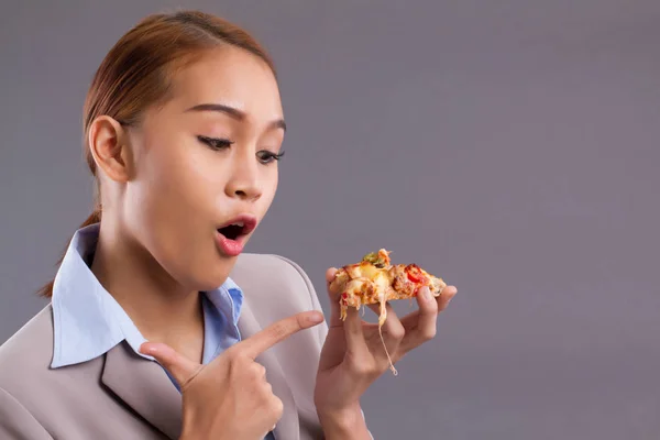 Happy smiling Asian woman eating pizza; Portrait of south east Asian woman holding, pointing at delicious italian pizza; enjoy eating pizza concept; Asian young adult, tan skin woman model