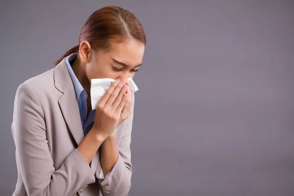 sick allergic woman sneezing; ill asian woman with dust or pollen allergy, polluted air, runny nose, cold, flu, illness; health care or air pollution concept; young adult tan skin asian woman model