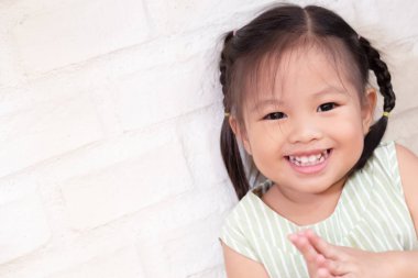 mutlu, memnun, gülümseyen pozitif Asya çocuk, sevimli küçük kız elini alkışlayan portre