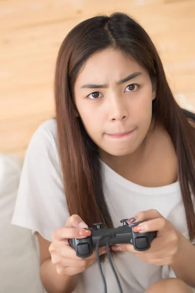 excited woman playing console video game. portrait of excited and fun asian woman plaing vdo game. hobby, liesure activity concept. asian young adult woman model