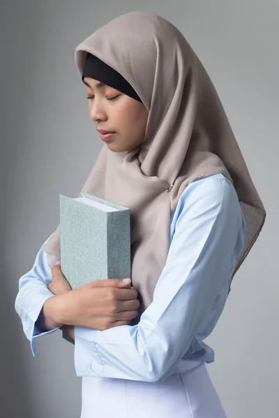 コーラン イスラム教の神聖な本を持つ若い大人のアジアのイスラム教徒の女性 ラマダンのコンセプト イード Fitr イスラム教の祈り イスラム教の宗教教育 イスラム教の宗教活動 — ストック写真