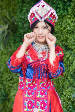 Geleneksel Hmong genç kadın portresi; Doğu Asya ve güneydoğu Asya 'daki Hmong veya Miao halkının geleneksel renkli giysi kültürü içinde Asyalı etnik kabile insanları