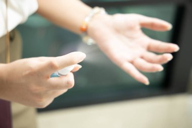 Palmiye derisindeki mikropları öldürmek için alkol el spreyi kullanan insanlar; el dezenfeksiyonu için alkol spreyi, yüzey dezenfektanına dokunmak, Coronavirus covid-19 için el dezenfektanı, sağlık hizmetleri