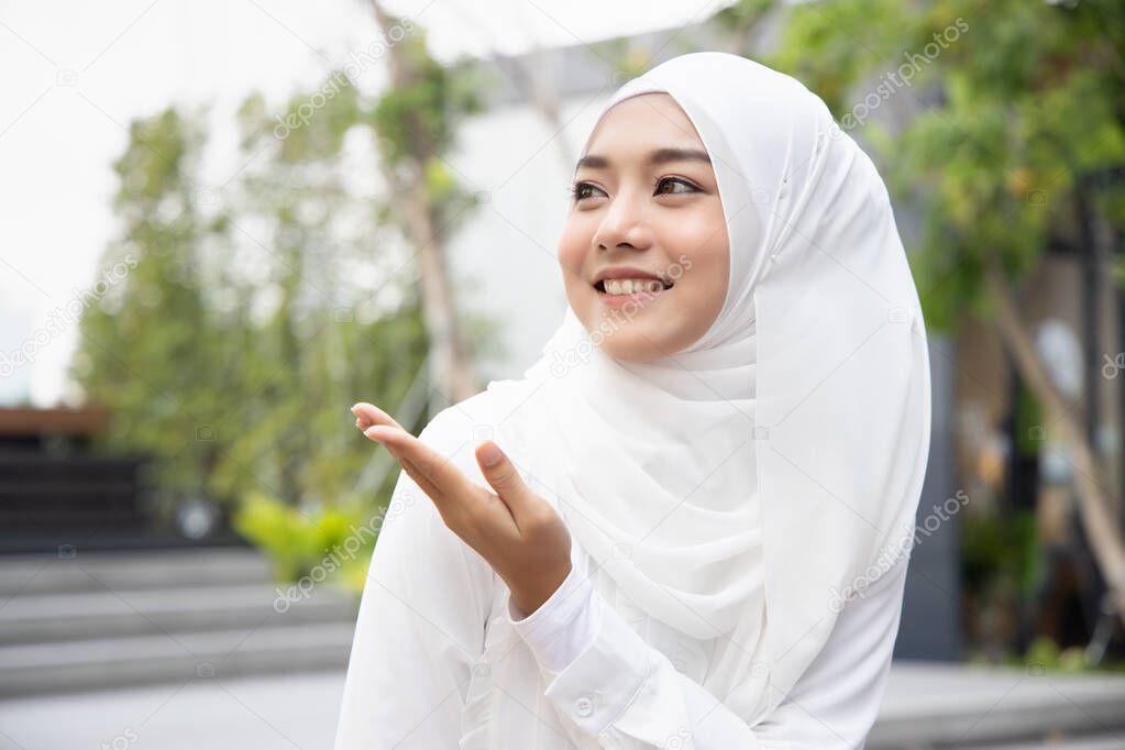 happy muslim woman pointing up