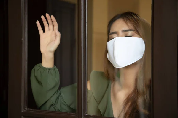 sad woman wearing face mask and staying home