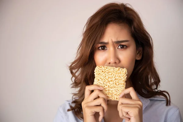 unhappy, sad girl having instant noodle, concept of cheap budget fast food for jobless girl, unemployed people, month end, no money, no income