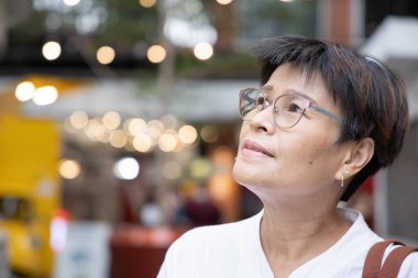 Orta yaşlı kadın yukarı bakıyor.