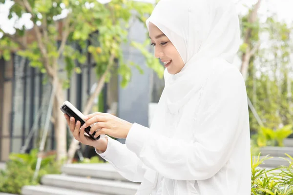 Szczęśliwa Muzułmanka Korzystająca Bezprzewodowej Ładowarki Smartfonów Przenośnego Bezprzewodowego Urządzenia Ładującego — Zdjęcie stockowe