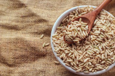 Ham kahverengi pirinç bir kaşık ve kase. üstten görünüm gıda arka plan