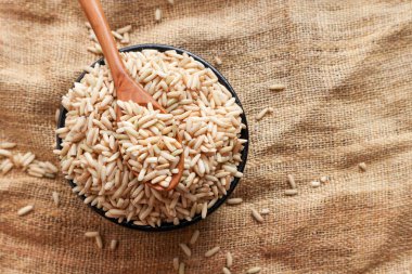 Ham kahverengi pirinç bir kaşık ve kase. üstten görünüm gıda arka plan