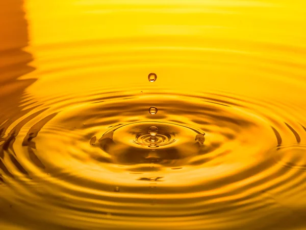 Close Van Een Druppel Olie Een Gele Achtergrond — Stockfoto