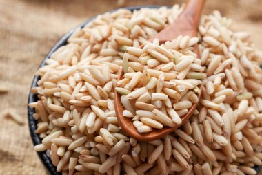 Ham kahverengi pirinç bir kaşık ve kase. üstten görünüm gıda arka plan