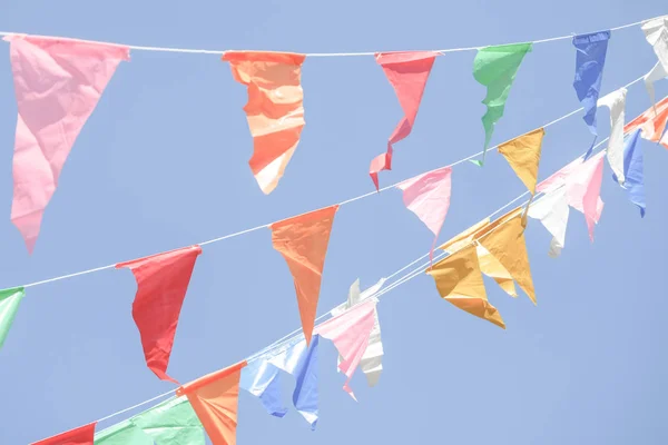 Colorful Party flags bunting hanging on blue sky for holiday decoration