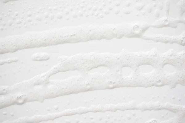 Fondo abstracto textura de espuma jabonosa blanca. espuma de champú con — Foto de Stock