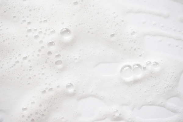 Fond abstrait texture de mousse savonneuse blanche. Shampooing mousse avec — Photo