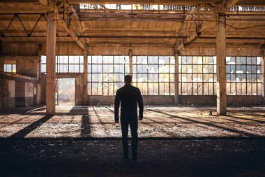 Yakışıklı adam yürümek boş fabrika