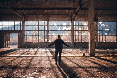Yakışıklı adam yürümek boş fabrika